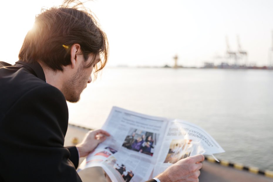 Successful businessman reading newspaper