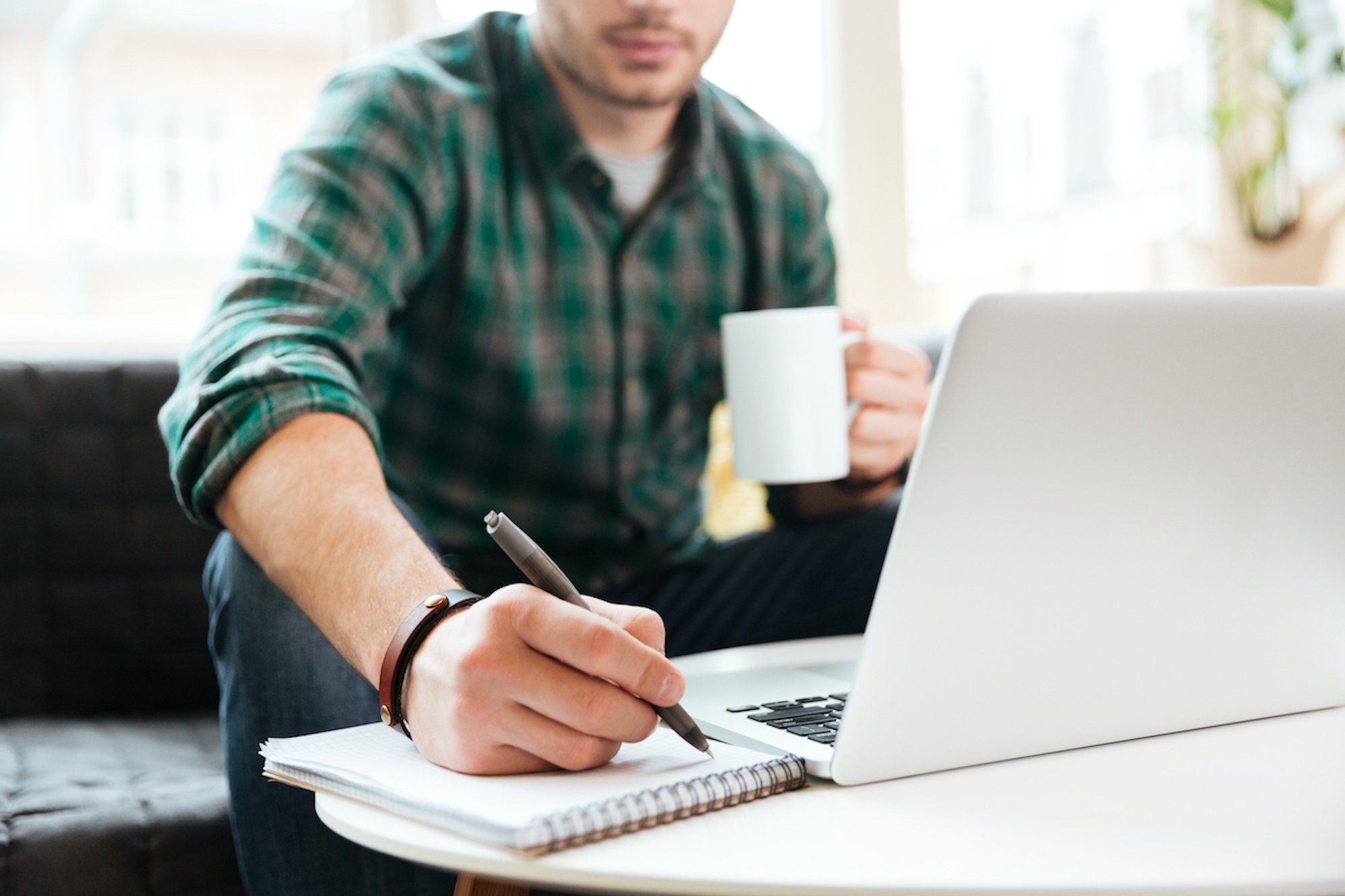 Cropped image of man with laptop on sofa